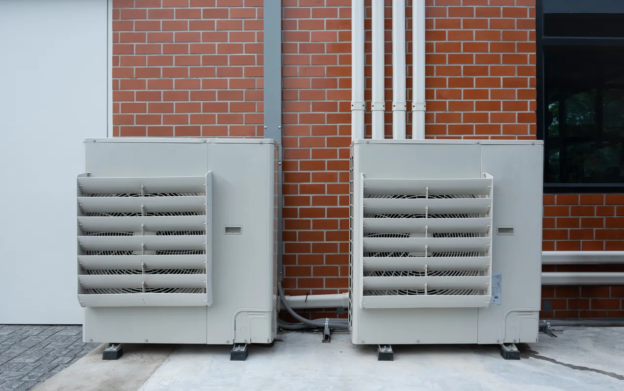 Unidades exteriores de bombas de calor de aerotermia instaladas junto a una fachada